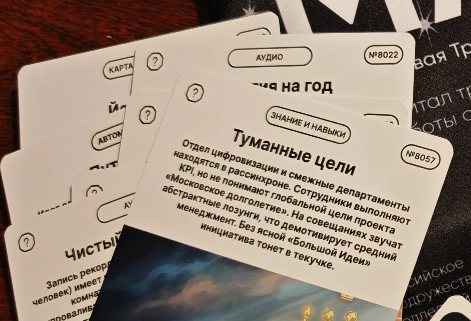 Две карточки заданий крупным планом: на верхней бейдж «Аудио» и номер 8022, на нижней бейдж «Знание и навыки», номер 8057 и задание про рассинхрон отдела цифровизации
